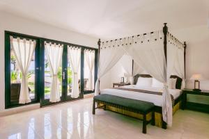 Rúm í herbergi á Legong Keraton Beach Hotel