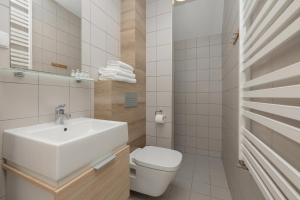 a white bathroom with a sink and a toilet at Na Fali Restaurant&Apartaments in Pobierowo +50 photos