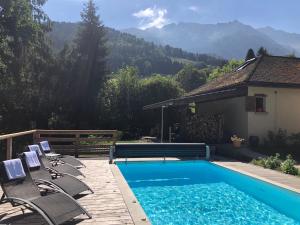 a swimming pool with lounge chairs next to a house at Gîtes du Grand Replomb in Sainte-Agnès