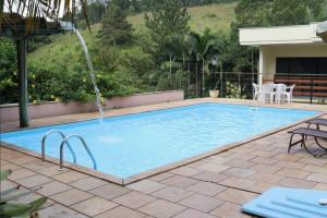 a swimming pool with a water fountain at Pousada Casarão Gastehaus in Pomerode