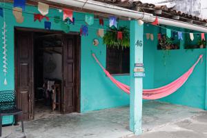 a blue building with a hammock in front of it at Casa Maria Flor Guest House in Itacaré