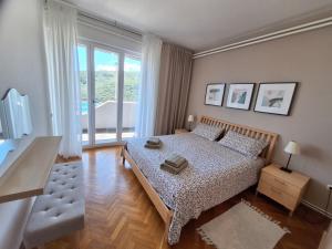 a bedroom with a bed and a large window at Apartments Dunja in Rabac +45 photos