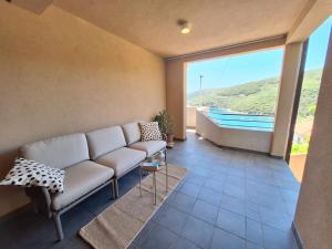 a living room with a couch and a large window at Apartments Dunja in Rabac