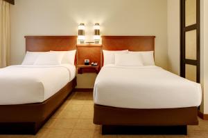 2 Betten in einem Hotelzimmer mit weißen Kissen in der Unterkunft Hyatt Place Fort Wayne - Northwest in Fort Wayne