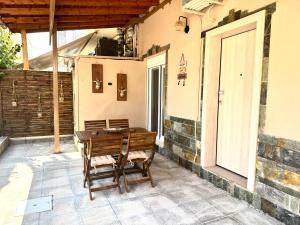 a wooden table and chairs on a patio at Olea Central Stay in Nea Kalikratia