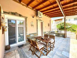 a wooden table and chairs on a patio at Olea Central Stay in Nea Kallikrateia