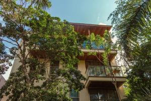a building with trees in front of it at Master Jungle Penthouse with Large Private Terrace - Santuario Hotel Boutique in Chemuyil