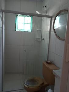 ein Bad mit einem WC und einer Dusche mit einem Fenster in der Unterkunft Chalé da Sheila in São Sebastião