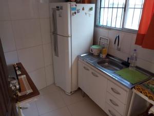 eine Küche mit einem weißen Kühlschrank und einer Spüle in der Unterkunft Chalé da Sheila in São Sebastião