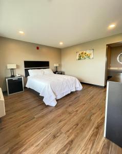 a bedroom with a bed and a wooden floor at Four Seasons Inn in Gallipolis