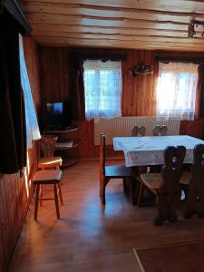 a dining room with a table and chairs and a television at Chata Carla in Žiar
