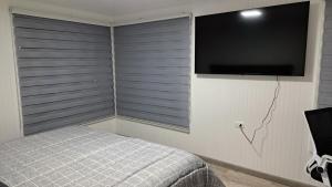a bedroom with a bed and a flat screen tv at Cabin with an ocean view in Coquimbo