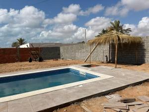 a swimming pool in a yard next to a brick wall at Riad Houch Amine B&B in Midoun