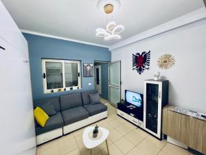 a living room with a couch and a tv at Rajs Apartment in Tirana