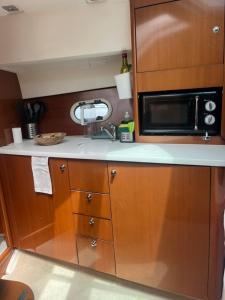 a kitchen with a sink and a microwave at Sea Bloom II - Night in a Fancy Speedboat in Lisbon