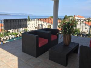 a patio with a couch and a table and a vase at Apartments Antonia in Malinska