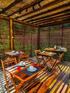 a patio with tables and chairs on a wooden deck at Pousada HAI in Fernando de Noronha