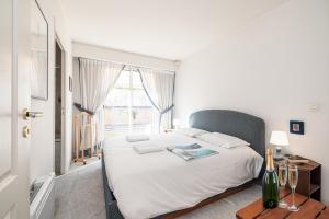 een slaapkamer met een groot wit bed en een raam bij Victoria Sole & Mare in Menton