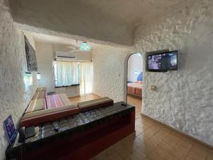 a bedroom with a bed and a tv on a wall at Villa Hotel Puerta del Mar in Ixtapa