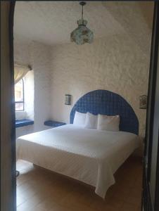 a bedroom with a large bed with a blue headboard at Villa Hotel Puerta del Mar in Ixtapa +14 photos