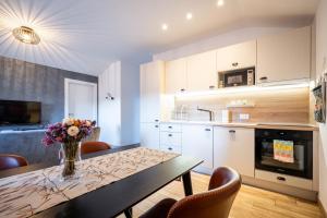 a kitchen with a table with a vase of flowers on it at Unique city center Apartments Gran Fenice with free garage parking and roof terrace in one of the apartments in Rijeka