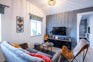 a living room with a couch and a tv at Unique city center Apartments Gran Fenice with free garage parking and roof terrace in one of the apartments in Rijeka