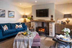 a living room with a blue couch and a fireplace at Lilycombe Farm in Bath