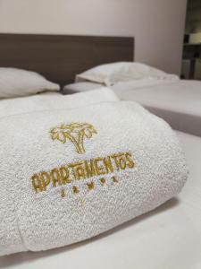 um cobertor branco sobre duas camas em Aptos super confortáveis no Gold Flat by Apartamentos Jampa em João Pessoa