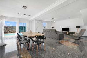 a living room with a table and chairs and a couch at Villa Edén House by Maspalomas Holiday Villas in Maspalomas