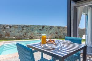 a table with a bowl of fruit on it next to a pool at Villa Edén House by Maspalomas Holiday Villas in Maspalomas