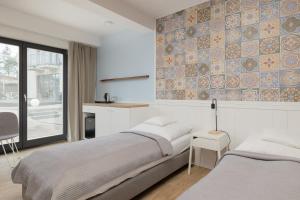 a bedroom with two beds and a table and a kitchen at Na Fali Restaurant&Apartaments in Pobierowo