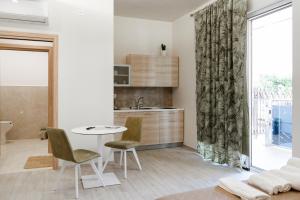 a kitchen with a table and chairs and a sink at Geranium B&B in Bitonto