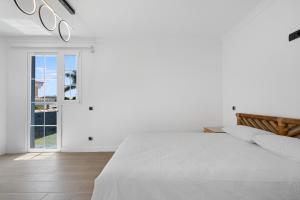 a white bedroom with a large bed and a window at Villa Edén House by Maspalomas Holiday Villas in Maspalomas +14 photos