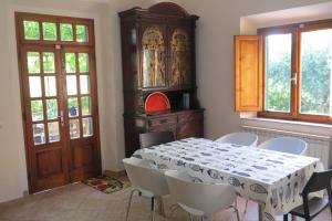 a dining room with a table and chairs and a cabinet at A garden on the bay in Castiglioncello