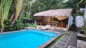 une piscine devant une maison avec une cabane dans l'établissement Villa Subak 3 bed room, à Ubud