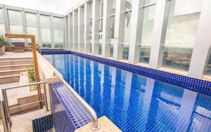 a large swimming pool in a building with windows at V1114 Flat com WI-FI exclusivo, academia e piscinas in Brasilia