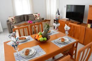 a dining room table with food and fruit on it at Mitsakos Golden Villa in Egina