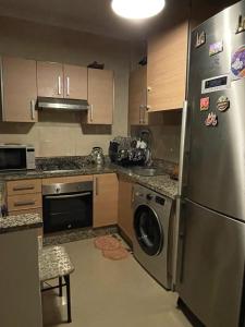 a kitchen with a stainless steel refrigerator and a dishwasher at Apparemment de luxe Asilah Marina Golf in Asilah