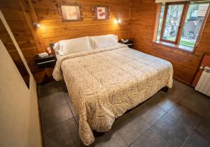 ein Schlafzimmer mit einem Bett in einer Holzhütte in der Unterkunft Guardianes Del Bayo in Villa La Angostura