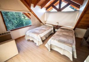 zwei Betten in einem Zimmer mit Fenster in der Unterkunft Guardianes Del Bayo in Villa La Angostura + 39 Fotos