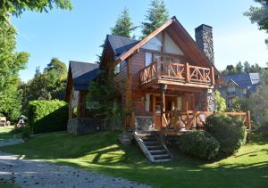 a log house with a porch and a deck at Guardianes Del Bayo in Villa La Angostura