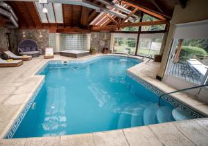 an indoor pool with blue water in a house at Guardianes Del Bayo in Villa La Angostura