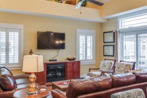 a living room with leather furniture and a flat screen tv at Seaside Serenity in Corolla