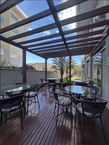 un patio con mesas y sillas en una terraza en Pousada Casarão Schmidt, en Pomerode