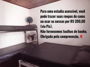 Casa Temporada no Rio de Janeiro في ريو دي جانيرو: غرفة بسريرين بطابقين مع وضع علامة على الحائط