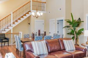 a living room with a leather couch and a table at Seaside Serenity in Corolla
