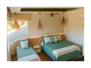 a bedroom with two beds and a window at Palmares, Casa de praia in Búzios