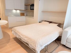 a bed in a small room with a kitchen at Studio Nacre Knokke in Knokke-Heist