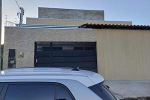 a white car parked in front of a garage at Casinha top perto Águas Quentes in Barra do Garças