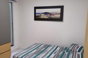 a picture hanging on a wall next to a bed at Casinha top perto Águas Quentes in Barra do Garças